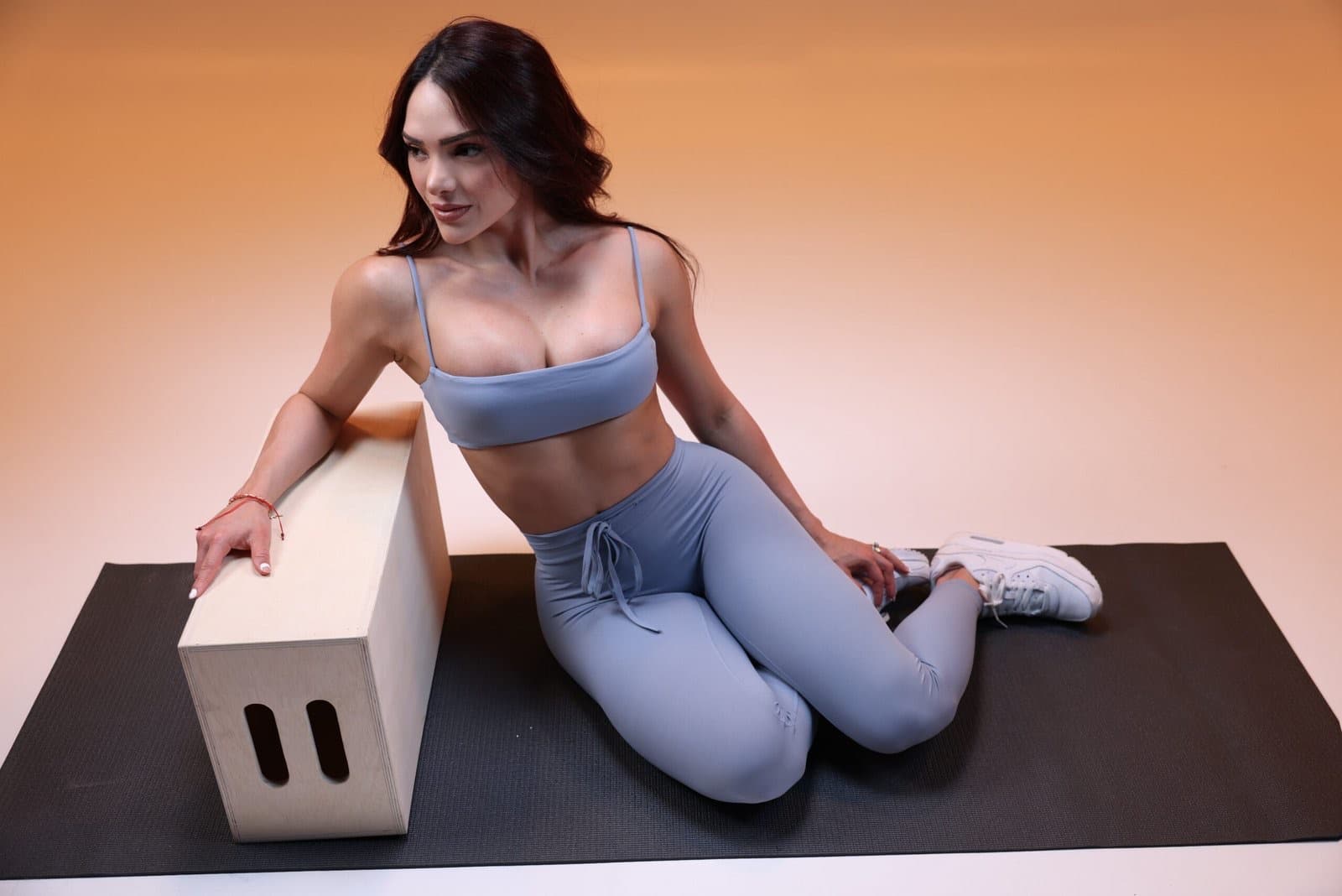 Taneth in a powder-blue set on a mat by a plyo box