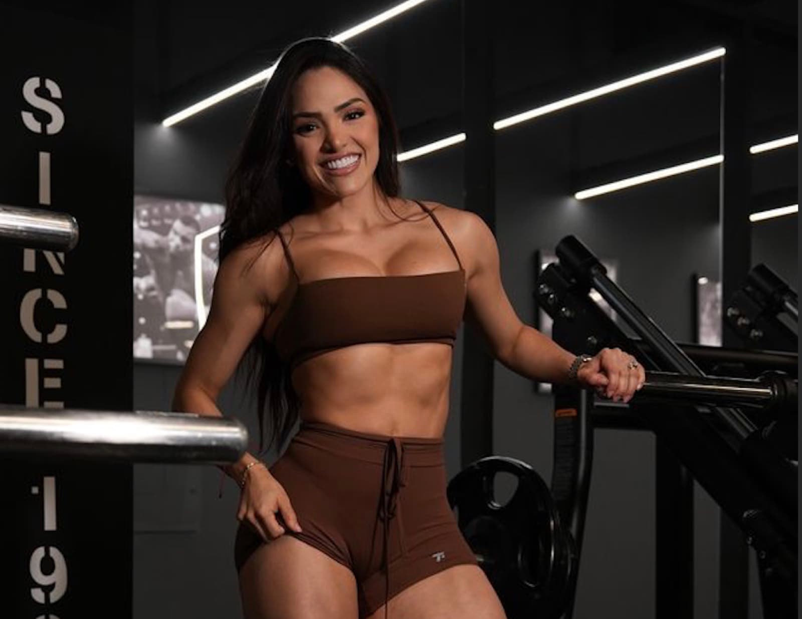 Taneth smiling in a dark gym